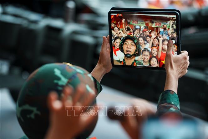 Một chiến sĩ chụp ảnh cùng với người dân hai bên đường. Ảnh: Phạm Tuấn Anh - TTXVN