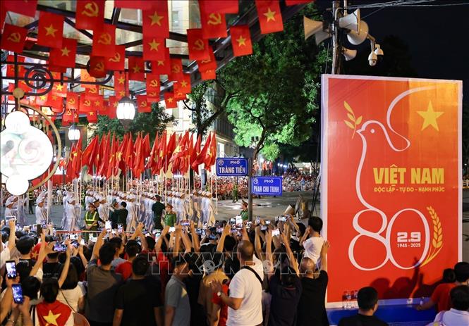 Người dân chăm chú theo dõi, cổ vũ các khối di chuyển trên phố Tràng Tiền về Quảng trường Cách mạng tháng Tám. Ảnh: Thanh Tùng - TTXVN