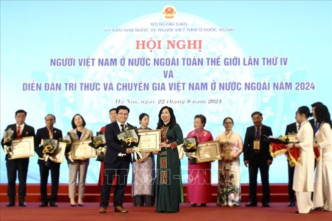 Tổng biên tập Tạp chí Hương Việt Phạm Khánh Nam nhận Bằng khen của Bộ trưởng Ngoại giao vì đã có thành tích xuất sắc trong công tác xây dựng phát triển cộng đồng người Việt ở nước ngoài, hướng về quê hương đất nước. Ảnh: TTXVN 
