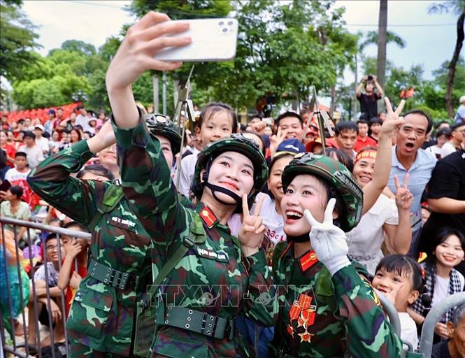 Các nữ chiến sĩ thông tin chụp ảnh kỷ niệm với người dân Hà Nội trươc giờ tổng hợp luyện. Ảnh: Hoàng Hà-TTXVN