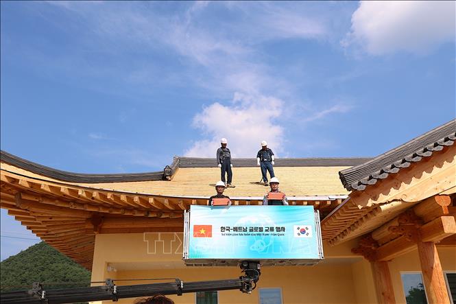 Đưa ngói lên cất nóc Nhà Cộng đồng. Ảnh: Khánh Vân - PV TTXVN tại Hàn Quốc 