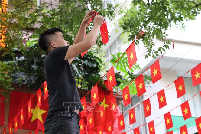Người dân trên phố Hai Bà Trưng tích cực trang hoàng nhà cửa bằng cờ Tổ quốc và cờ Đảng, chuẩn bị cho ngày lễ trọng đại. Ảnh: Vũ Quang – TTXVN