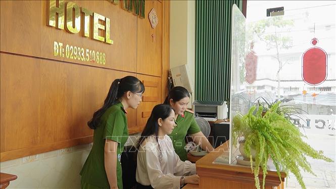 Thiếu tá Nguyễn Hồng Tươi (phải), cán bộ Công an phường Long Mỹ, thành phố Cần Thơ cùng đồng đội hướng dẫn người dân đăng ký lưu trú trên cổng dịch vụ công trực tuyến. Ảnh: TTXVN phát