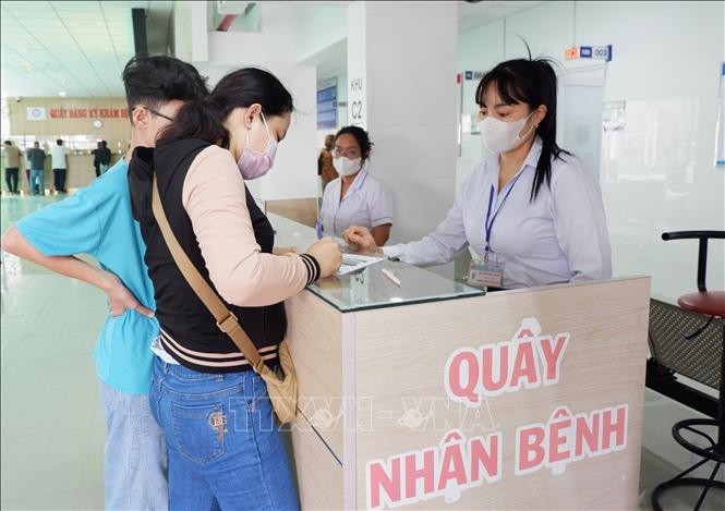 Nhân viên y tế Bệnh viện Đa khoa Long An hướng dẫn người dân làm thủ tục. Ảnh: Đức Hạnh - TTXVN 
