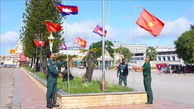 Bộ đội Biên phòng tỉnh Tây Ninh và Cảnh sát Biên phòng Campuchia chỉnh trang quốc kỳ 2 nước tại cặp cửa khẩu quốc tế Mộc Bài – Bavet. Ảnh: Minh Phú - TTXVN