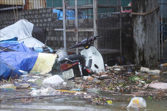 Xe máy của người dân để trước cổng ngõ bị nước biển dâng ngập. Ảnh: Xuân Tiến - TTXVN 