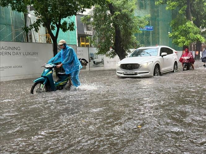 Ngập trên phố Đặng Thái Thân, phường Cửa Nam. Một số mô tô bị chết máy, phải dắt bộ. Ảnh: Lâm Khánh - TTXVN