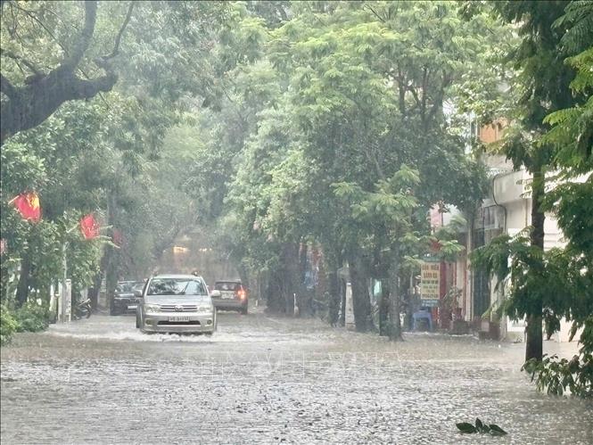 Mưa lớn tiếp tục trút xuống vào giờ đi làm gây rất nhiều khó khăn cho việc di chuyển của người dân. Ảnh: Tuấn Anh - TTXVN