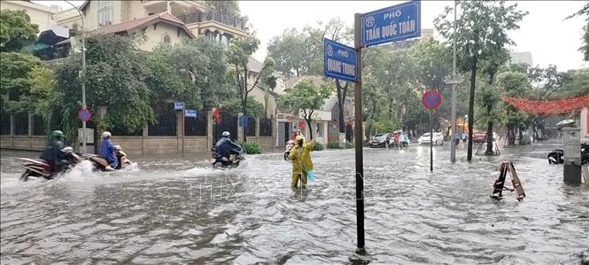 Phố Quang Trung ngập sâu ảnh hưởng trực tiếp đến cuộc sống của người dân. Ảnh: Hoàng Hiếu - TTXVN