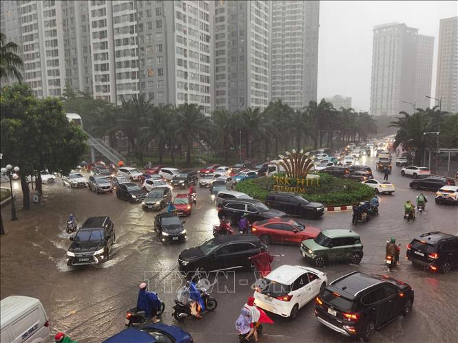 Mưa lớn ảnh hưởng đến việc di chuyển của người dân đầu giờ sáng tại KĐT Times City. Ảnh: Thanh Tùng - TTXVN