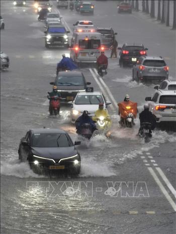 Mưa lớn ảnh hưởng đến việc di chuyển của người dân đầu giờ sáng tại KĐT Times City. Ảnh: Thanh Tùng - TTXVN