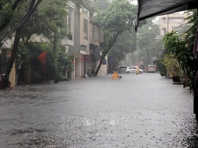 Phố Nguyễn Gia Thiều ngập sâu, ảnh hưởng đến cuộc sống của người dân Thủ đô. Ảnh: Hoàng Hiếu - TTXVN