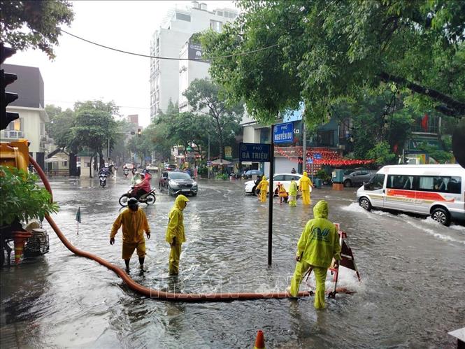 Các đơn vị chức năng nỗ lực thoát nước trong cơn mưa lớn. Ảnh: Hoàng Hiếu - TTXVN