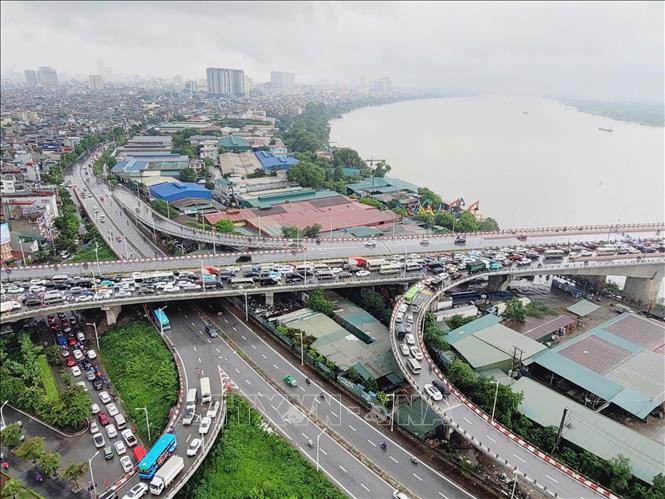 Nhiều phương tiện gặp khó khăn khi di chuyển trên đường dẫn lên cầu Vĩnh Tuy. Ảnh: Doãn Tấn - TTXVN