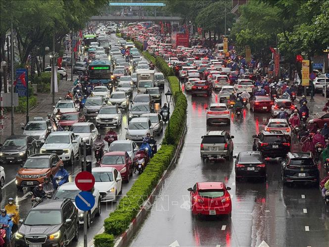 Nhiều phương tiện gặp khó khăn khi di chuyển trên đường Nguyễn Văn Cừ. Ảnh: Minh Quyết - TTXVN