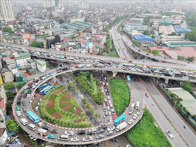 Nhiều phương tiện gặp khó khăn khi di chuyển trên đường dẫn lên cầu Vĩnh Tuy. Ảnh: Doãn Tấn -TTXVN