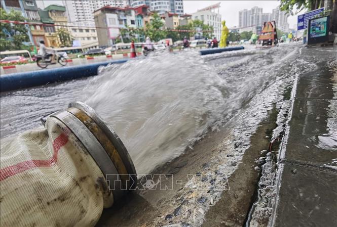 Công nhân ứng trực, xử lý thoát nước trên phố Minh Khai. Ảnh: Thanh Tùng - TTXVN