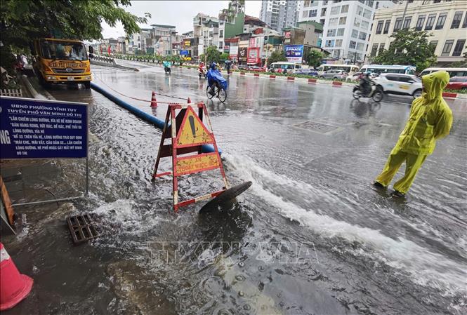 Công nhân ứng trực, xử lý thoát nước trên phố Minh Khai. Ảnh: Thanh Tùng - TTXVN