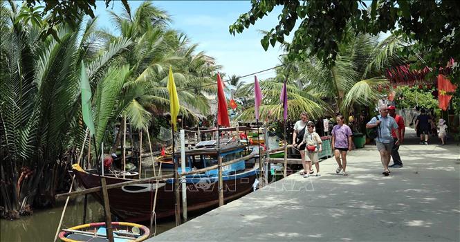 Visitors at Bay Mau coconut forest. VNA Photo: Đỗ Trưởng