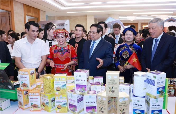 Thủ tướng Phạm Minh Chính tham quan trưng sản phẩm OCOP tại Hội nghị tổng kết Chương trình và Phong trào thi đua “Cả nước chung tay xóa nhà tạm, nhà dột nát”. Ảnh: Dương Giang-TTXVN 