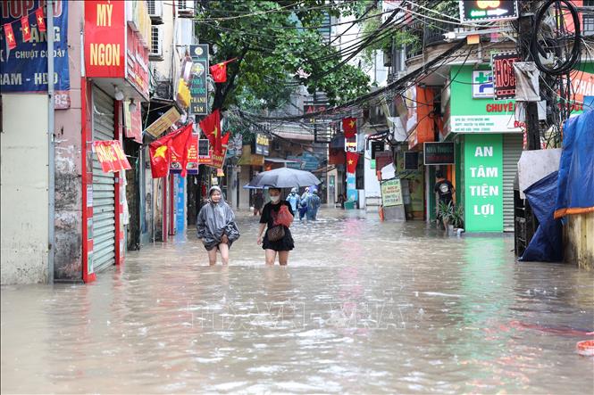 Người dân tại phố Triều Khúc di chuyển khó khăn do ngập úng. Ảnh: Vũ Quang - TTXVN