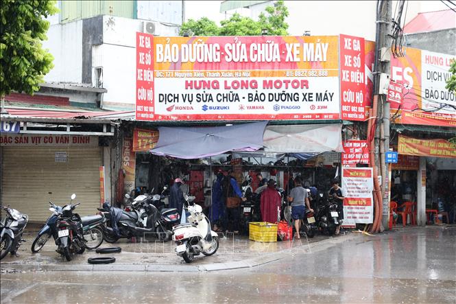 Nhiều phương tiện bị chết máy do ngập úng, phải mang đến các cửa hàng sửa chữa xe máy để khắc phục. Ảnh: Vũ Quang - TTXVN