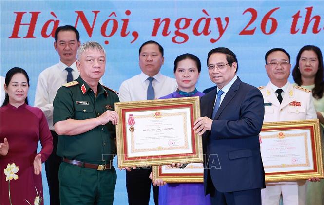 Thủ tướng Phạm Minh Chính trao Huân chương Lao động hạng Ba cho các tập thể có thành tích xuất sắc trong Phong trào thi đua “Cả nước chung tay xóa nhà tạm, nhà dột nát”. Ảnh: Dương Giang-TTXVN 
