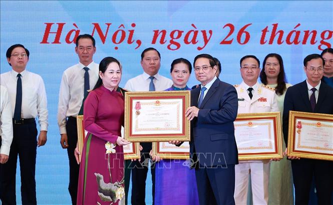 Thủ tướng Phạm Minh Chính trao Huân chương Lao động hạng Ba cho các tập thể có thành tích xuất sắc trong Phong trào thi đua “Cả nước chung tay xóa nhà tạm, nhà dột nát”. Ảnh: Dương Giang-TTXVN 
