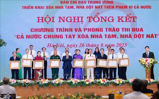 Thủ tướng Phạm Minh Chính trao Huân chương Lao động hạng Ba cho các tập thể có thành tích xuất sắc trong Phong trào thi đua “Cả nước chung tay xóa nhà tạm, nhà dột nát”. Ảnh: Dương Giang-TTXVN 
