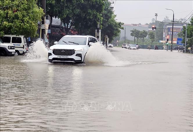 Mặc dù bị ngập sâu nhưng nhiều xe ô tô vẫn cố tình tìm cách để vượt qua. Ảnh: Tạ Toàn - TTXVN