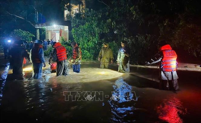 Lực lượng chức năng sử dụng mô tô nước vượt dòng nước xiết tiếp cận và giải cứu 3 nạn nhân trong ngôi nhà ngập sâu tầng 1, nước chảy xiết bao quanh, nguy cơ sập đổ rất lớn tại xã Sao Vàng. Ảnh: TTXVN phát 
