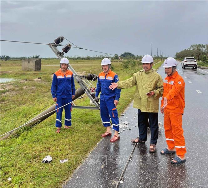 Cán bộ điện lực kiểm tra, xử lý sự cố ở xã Cẩm Xuyên. Ảnh: Công Tường-TTXVN