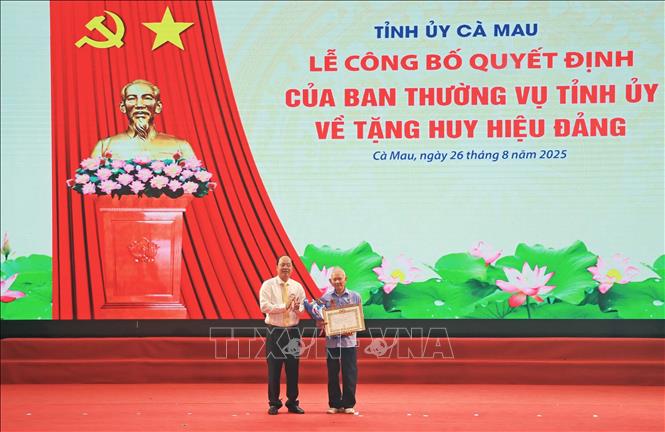 Bí thư Tỉnh ủy Cà Mau Nguyễn Hồ Hải trao Huy hiệu 65 năm tuổi Đảng cho đảng viên Nguyễn Anh Sơn. Ảnh: Huỳnh Anh - TTXVN