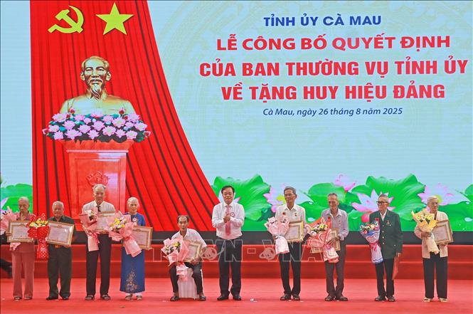 Phó Bí thư Thường trực Tỉnh uỷ Cà Mau Huỳnh Quốc Việt trao Huy hiệu Đảng cho đảng viên cao niên tại buổi lễ. Ảnh: Huỳnh Anh - TTXVN