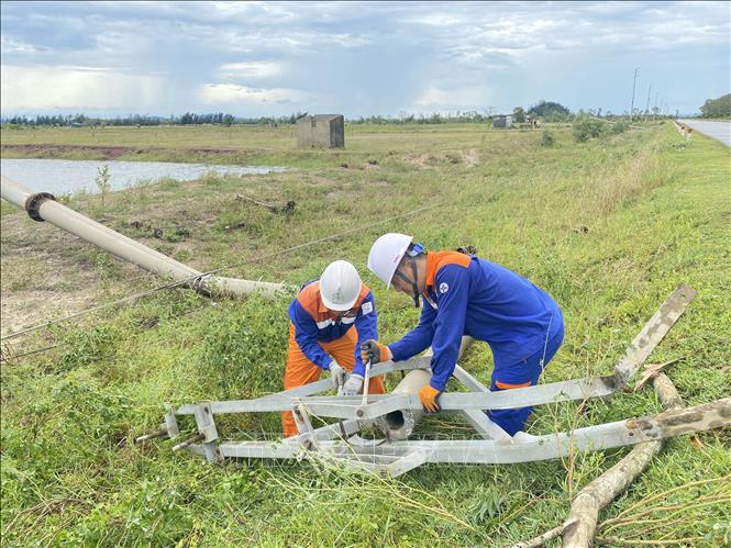 Công ty Điện lực Hà Tĩnh huy động lực lượng khắc phục tại các vị trí cột điện bị gãy, đổ. Ảnh: Hữu Quyết - TTXVN