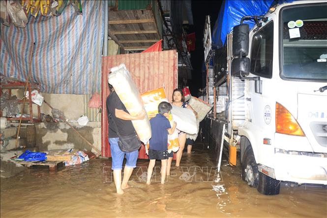 Người dân thuộc tổ dân phố Hồng Phú, phường Yên Bái, tỉnh Lào Cai tất bật dọn hàng hóa lên xe ô tô để di chuyển đến nơi an toàn.  Ảnh: Đinh Thùy - TTXVN