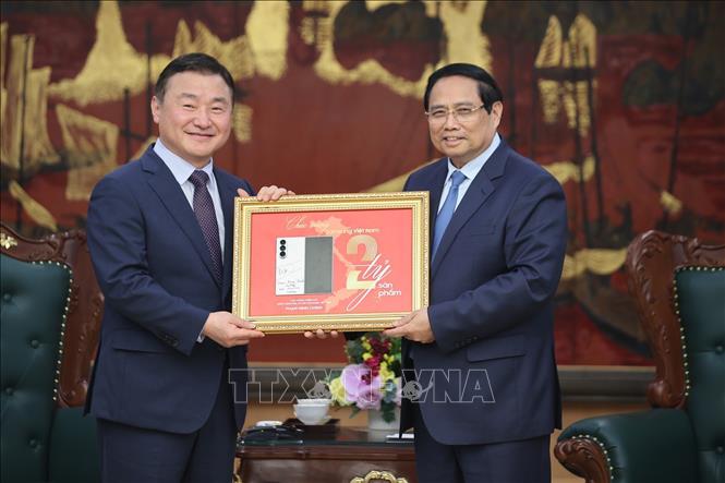 Thủ tướng Phạm Minh Chính ký tặng biển kỷ niệm sản xuất chiếc điện thoại di động thứ 2 tỷ của Samsung tại Việt Nam. Ảnh: Dương Giang-TTXVN
