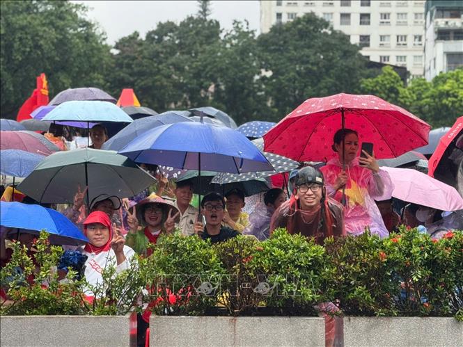 Tình yêu và niềm tự hào lớn hơn cơn mưa. Khoảnh khắc người dân Thủ đô không quản ngại thời tiết, kiên nhẫn chờ đợi và cổ vũ cho các lực lượng vũ trang. Ảnh: Minh Quyết - TTXVN