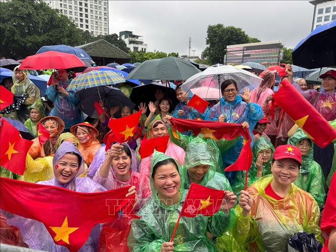 Tình yêu và niềm tự hào lớn hơn cơn mưa. Khoảnh khắc người dân Thủ đô không quản ngại thời tiết, kiên nhẫn chờ đợi và cổ vũ cho các lực lượng vũ trang. Ảnh: Minh Quyết - TTXVN