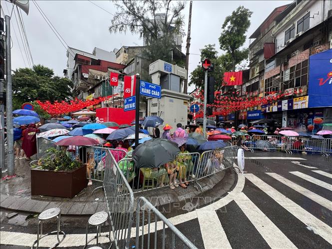 Bất chấp cơn mưa lớn, hàng nghìn người dân vẫn đổ về các tuyến phố chờ đợi chào đón các khối diễu binh hợp luyện cho Đại lễ 80 năm Quốc khánh. Ảnh: Minh Quyết - TTXVN