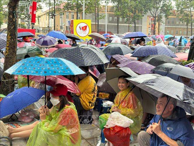 Tình yêu và niềm tự hào lớn hơn cơn mưa. Khoảnh khắc người dân Thủ đô không quản ngại thời tiết, kiên nhẫn chờ đợi và cổ vũ cho các lực lượng vũ trang. Ảnh: Minh Quyết - TTXVN