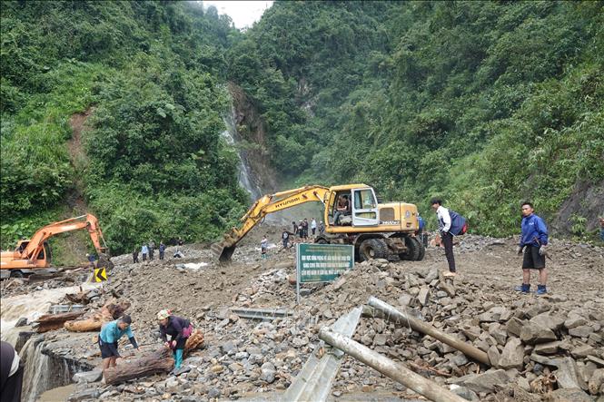 Lực lượng chức năng huy động máy móc khắc phục sự cố sạt lở trên Quốc lộ 32 thuộc đèo Khau Phạ, xã Tú Lệ. Ảnh: Tuấn Anh - TTXVN                               