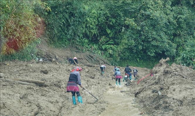 Người dân cùng với lực lượng chức năng tích cực thông tuyến Quốc lộ 32 đoạn từ xã Púng Luông đến xã Tú Lệ, tỉnh Lào Cai. Ảnh: Tuấn Anh - TTXVN