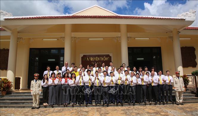 Các đại biểu chụp ảnh lưu niệm tại Nhà Truyền thống Khu căn cứ Ban Giao bưu vận và Ban Thông tin liên lạc Trung ương Cục miền Nam (xã Tân Lập, tỉnh Tây Ninh). Ảnh: Giang Phương - TTXVN