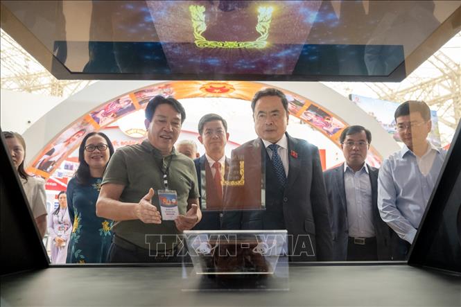 Chủ tịch Quốc hội Trần Thanh Mẫn nghe giới thiệu về công nghệ trình chiếu tại triển lãm. Ảnh: TTXVN 
