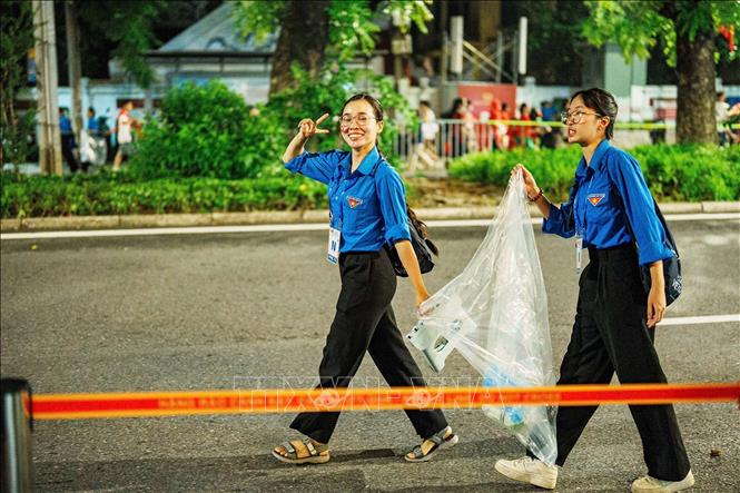 Các bạn tình nguyện viên thu gom rác sau buổi Sơ duyệt sự kiện A80. Ảnh: Phạm Tuấn Anh-TTXVN