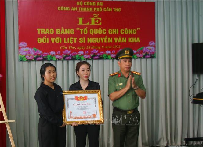 Đại tá Huỳnh Hoài Hận, Phó Giám đốc Công an thành phố Cần Thơ trao Bằng Tổ quốc ghi công cho thân nhân Liệt sĩ Nguyễn Văn Kha. Ảnh: Duy Khương - TTXVN