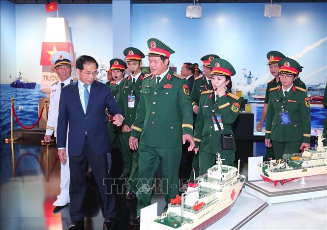 Phó Thủ tướng, kiêm Bộ trưởng Bộ Ngoại giao Bùi Thanh Sơn, Thượng tướng Vũ Hải Sản, Thứ trưởng Bộ Quốc phòng và các đại biểu tham quan khu trưng bày của Bộ Quốc phòng tại Triển lãm.  Ảnh: Trọng Đức - TTXVN