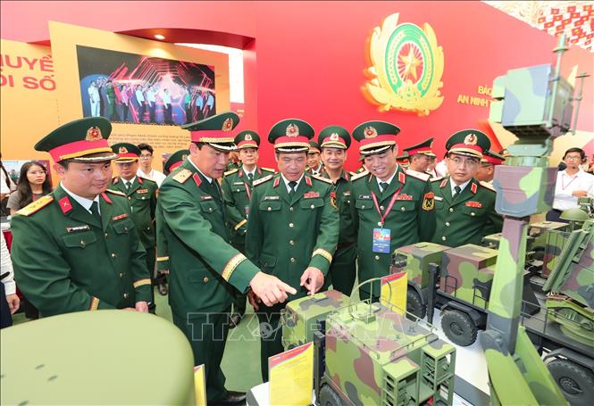  Thượng tướng Vũ Hải Sản, Thứ trưởng Bộ Quốc phòng và các đại biểu tham quan khu trưng bày các sản phẩm quốc phòng tại Triển lãm.  Ảnh: Trọng Đức - TTXVN