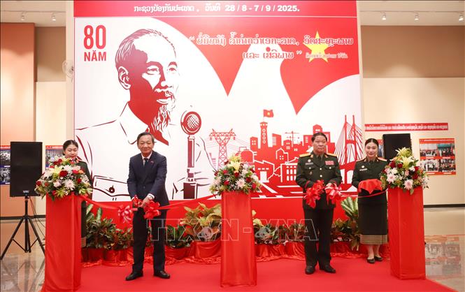 Đại sứ Việt Nam tại Lào Nguyễn Minh Tâm (bên trái) và Trung tướng Vongsone Inpanphim, Chủ nhiệm Tổng Cục Chính trị Quân đội, Thứ trưởng Bộ Quốc phòng Lào cắt băng khai mạc Triểm lãm ảnh chuyên đề Kỷ niệm Quốc khánh Việt Nam tròn 80 năm. Ảnh: Xuân Tú - PV TTXVN tại Lào